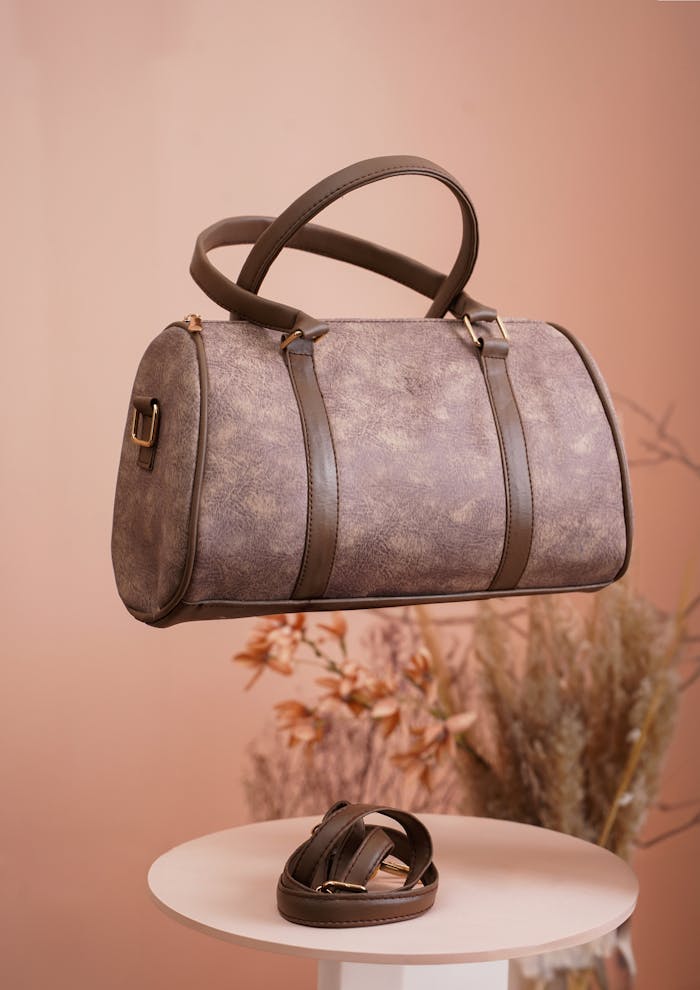 Stylish brown leather handbag with minimalist design in a studio setting.